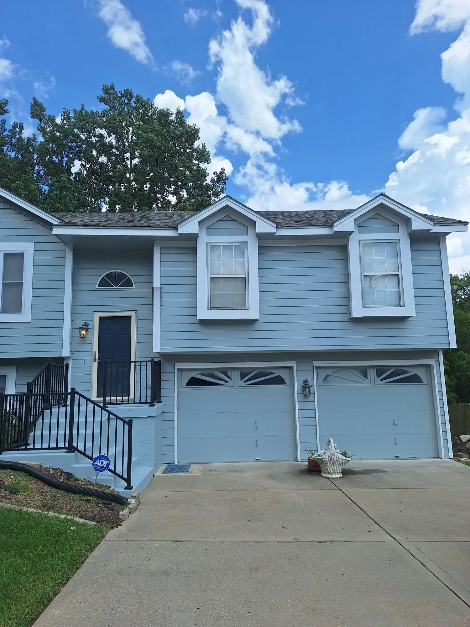House with pale blue siding and white trim after repainting