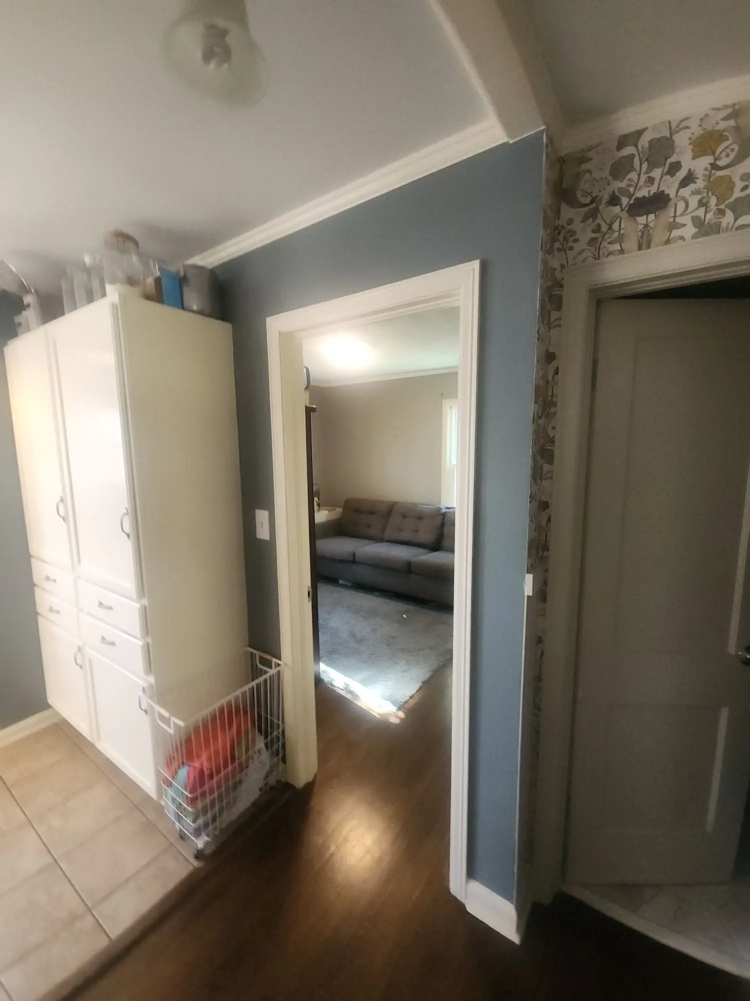 Hallway painted blue-grey with white trim and a wood floor