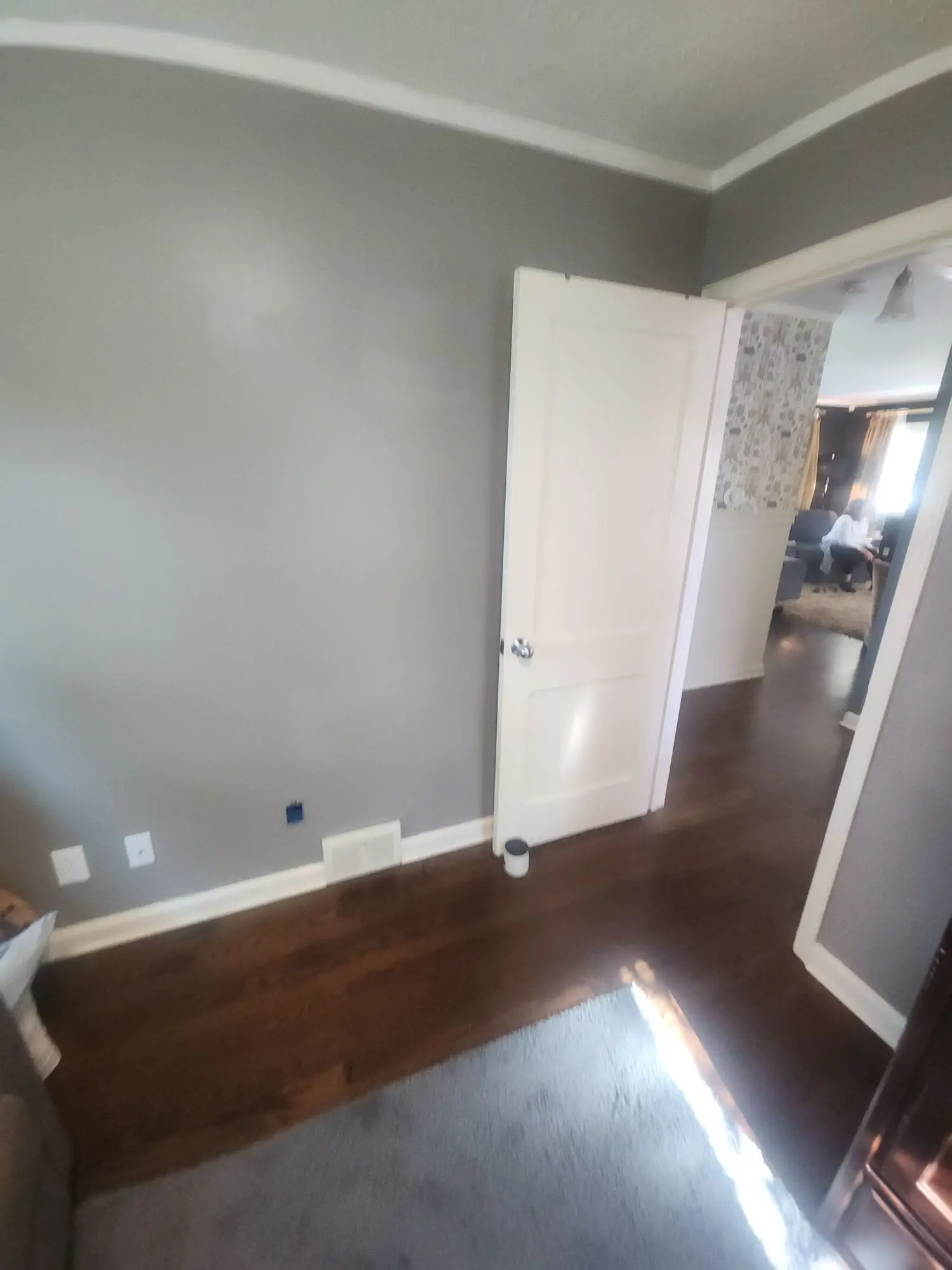 Room painted grey with crown moulding and a white door